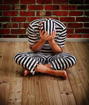 portrait of a repentant man prisoner in prison uniform