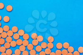 orange vitamin pills on a blue background