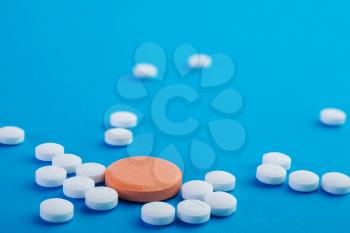 white and orange pills on a blue background 