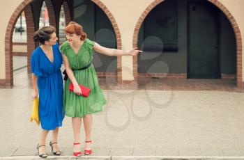 Two beautiful girls on the street in retro style.Urban scene with young women