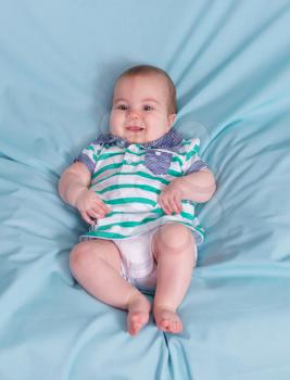Adorable happy baby boy on blue background.Focus on the face
