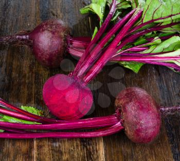  Fresh beetroots with leaves on wet wooden rustic table.Whole and cut  beetroots 