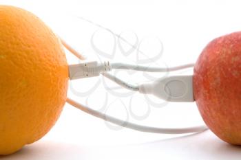 Royalty Free Photo of Cables Connecting an Apple and an Orange