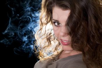 Royalty Free Photo of a Woman With Smoke Behind Her
