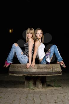 Royalty Free Photo of Two Girls Sitting Back to Back