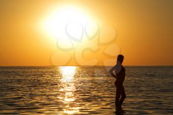 Royalty Free Photo of a Woman on the Beach at Sunset