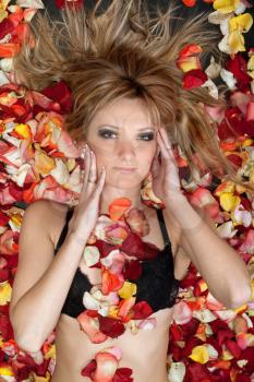 Royalty Free Photo of a Girl Lying on Rose Petals