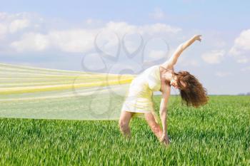 Flexible young woman in a green field 