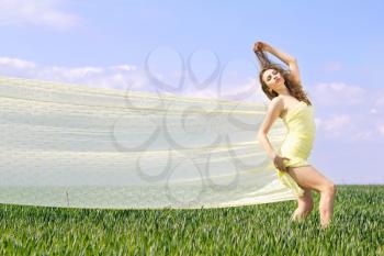 Young expressive beautiful woman in a green field 