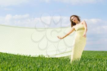 Young expressive cute woman in a green field  