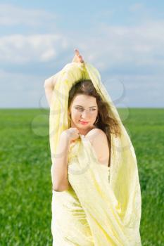 Portrait of a cute young woman wrapped in yellow cloth