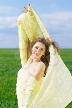 Portrait of a happy young woman wrapped in yellow cloth