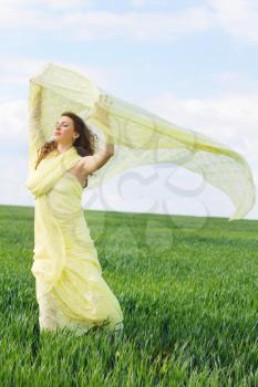 Young charming woman wrapped in yellow cloth