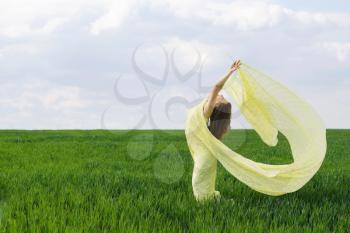 Cute girl dancing in a green field