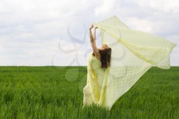 Nice girl dancing in a green field