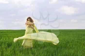 Young woman dancing in a green field