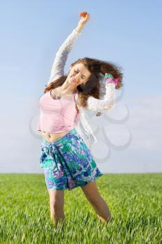 Cheerful nice young woman in a green field
