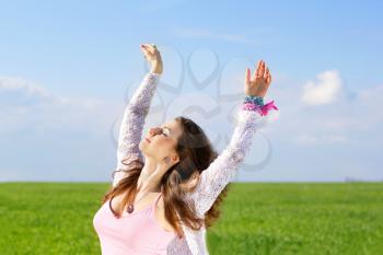 Portrait of happy cute young woman in a green field