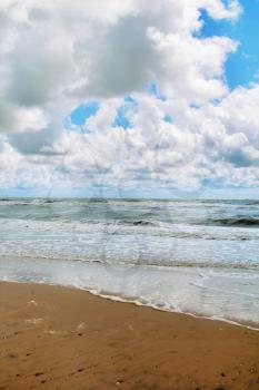 Cloudy blue sky over the stormy sea