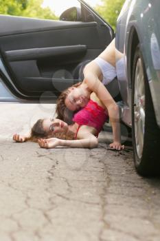 Two beautiful young women lying on the road