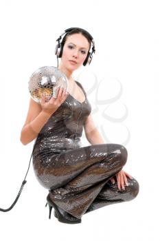 Sexy young brunette in headphones with a mirror ball. Isolated on white