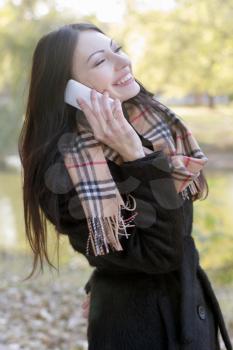 Portrait of happy young woman talking on a cell phone
