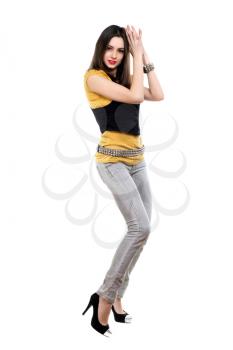 Pretty woman posing in grey jeans, yellow t-short and black vest. Isolated on white