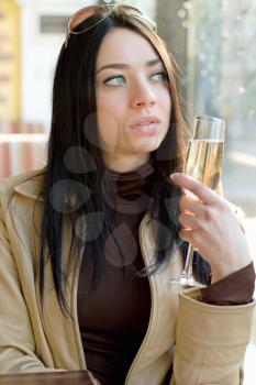 Thoughtful pretty woman posing with a glass of champagne. Isolated on white