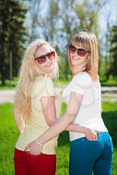 Two smiling blond women wearing sunglasses