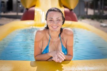 Pretty cheerful woman posing in the yellow swimming pool