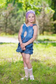 Beautiful little girl wearing jeans dress posing outdoors