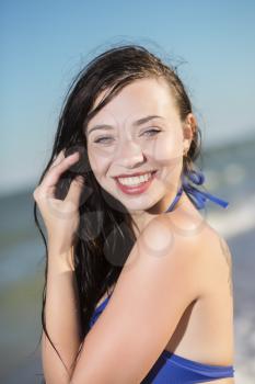 Portrait of pretty cheerful woman posing at the seaside