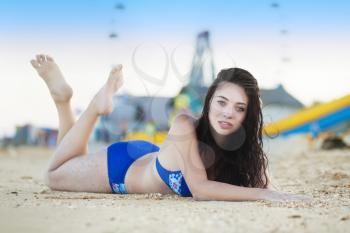 Young brunette posing on the sand near recreation park