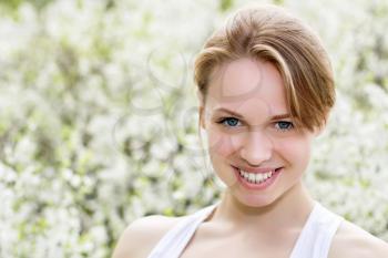 Portrait of pretty smiling young blond woman posing outdoors 