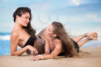 Two sexy slim women lying on the beach