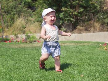 Joyful kid running around the lawn