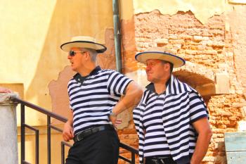 VENICE, ITALY - MAY 06, 2014: Two gondolier on the docks awaiting tourists in Venice, Italy