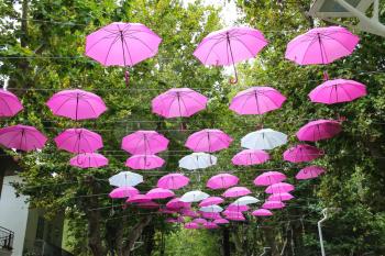 Pink and white umbrellas decorate streets in the resort town Bellaria Igea Marina, Rimini, Italy