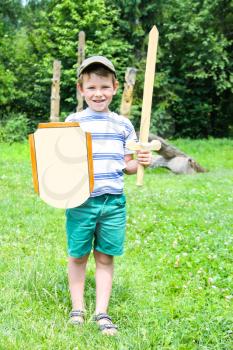 Cheerful boy with a wooden shield and sword