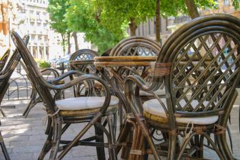 Outdoor street cafe with wooden furniture in touristic city centre