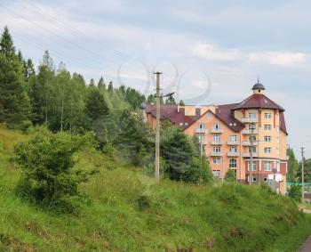 Modern apartment building on slope of forested mountains. Carpathians, Ukraine