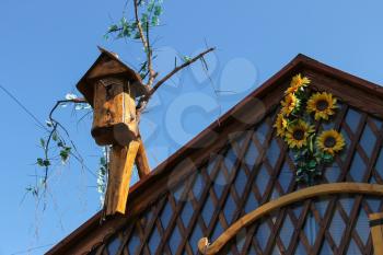 Old style birdhouse on wooden roof