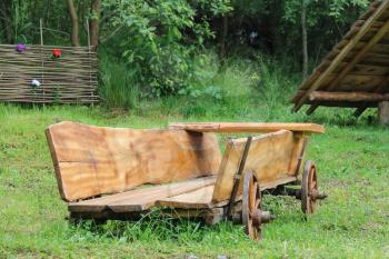 Decorative wooden cart on green grass in Carpatian park