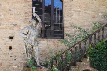 Grazzano Visconti, Italy - August 07, 2016: Old statue near stairs against stone wall