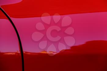 Reflections in side wing of red sport car