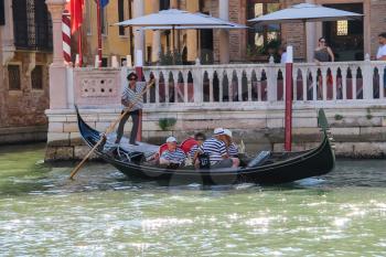 Venice, Italy - August 13, 2016: Tourists in gondolas on canal of Venice