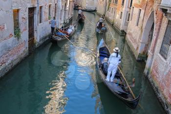 Venice, Italy - August 13, 2016: Tourists in gondolas on canal of Venice