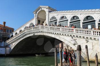Venice, Italy - August 13, 2016: Tourists walking on famous Rialto Bridge (Ponte di Rialto)
