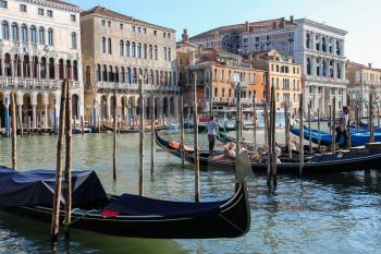 Venice, Italy - August 13, 2016: Tourists in gondola at the pier of Grand canal