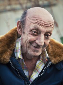 Portrait of a smiling elderly man outdoors closeup